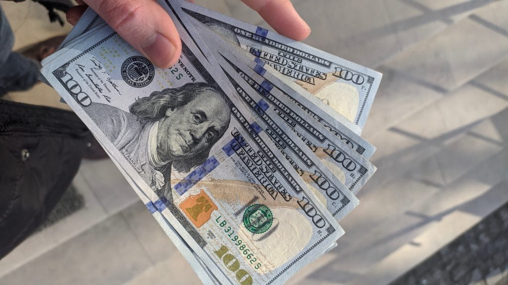 $100 bills in someones hand